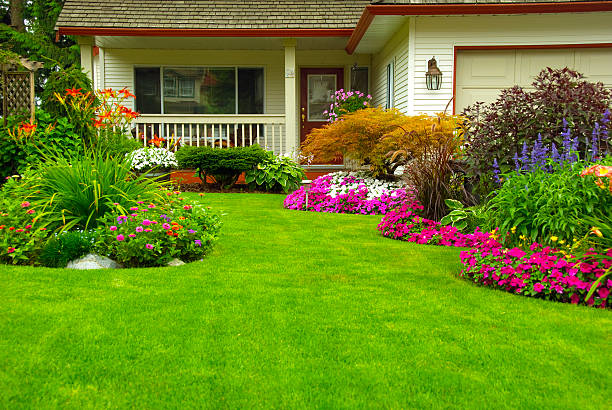 Colorful flowers, including pink, purple, and white blooms, surround lush green lawn located in an area known for exceptional landscaping in Keeneland KY.